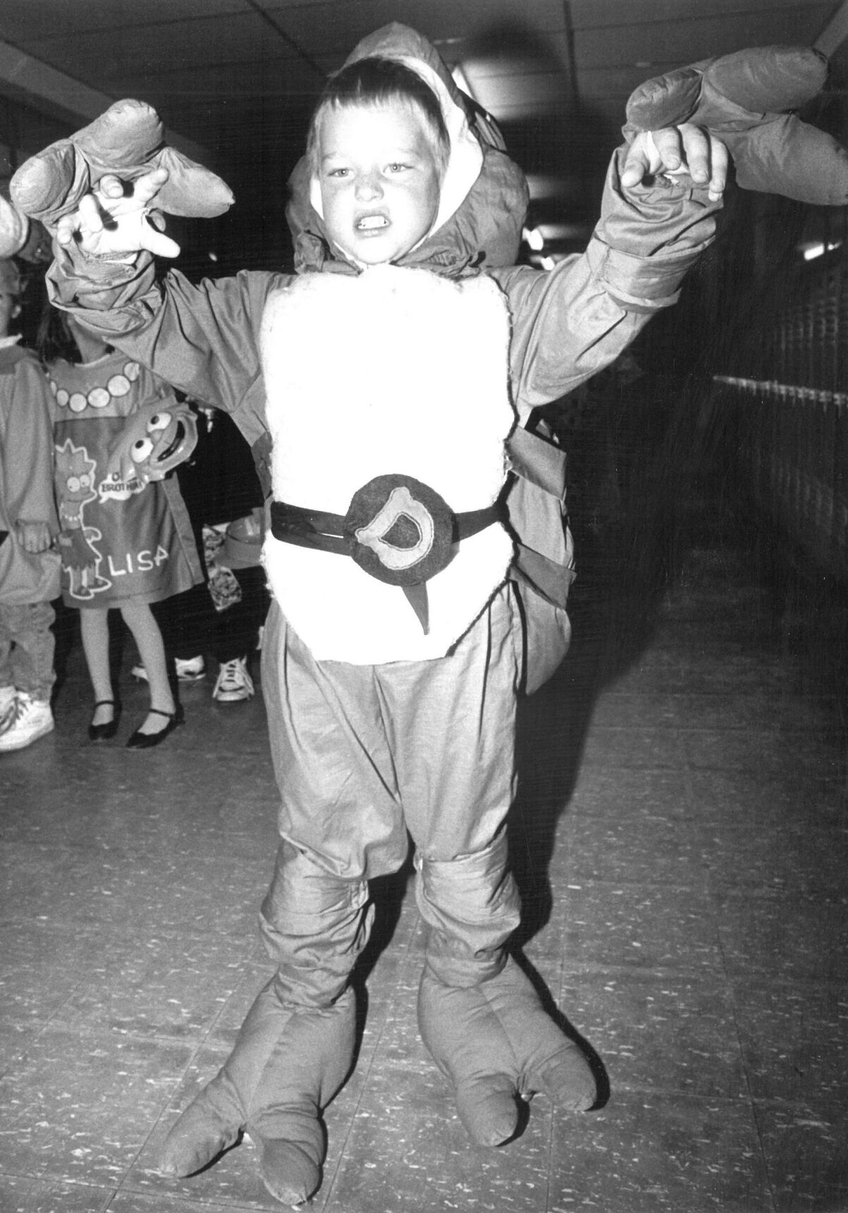 Sullivan School kindergarten student Joseph Lesure tries to scare his classmates during a class parade. Oct. 31, 1991.
